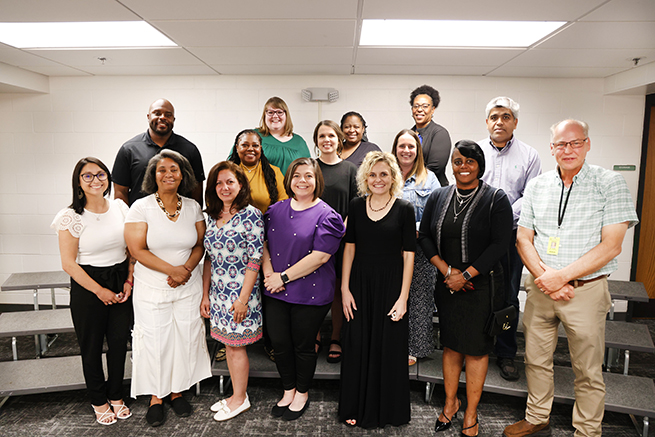 Staff members stand with awards for years of service