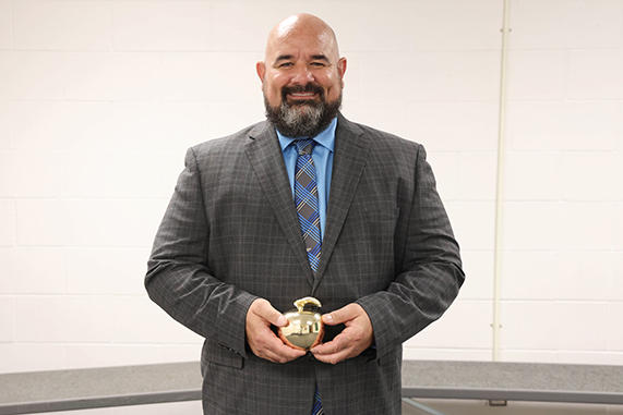 One employee stands with awards for years of service